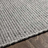 Close-up of the hand woven Innisfail Area Rug. Medium gray and black cotton rug with a textured, solid and striped design. Texture