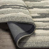 Close-up of the hand-tufted Irirum Area Rug. Charcoal, light beige, and gray wool create a contemporary striped pattern. Fold