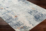 Close-up of the Iryna Area Rug showing its charcoal, brown, gray, and nutmeg contemporary design. Corner