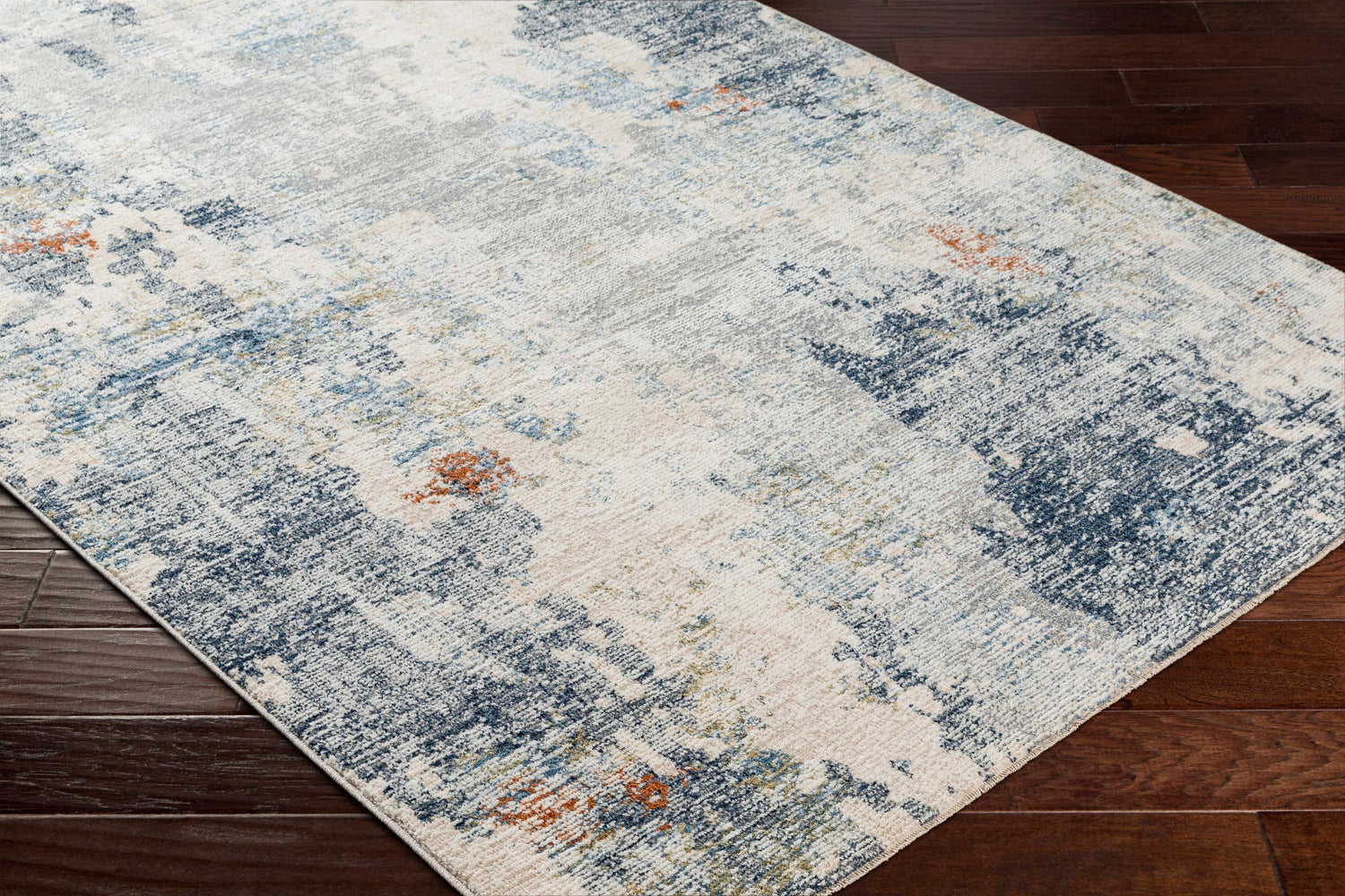 Close-up of the Iryna Area Rug showing its charcoal, brown, gray, and nutmeg contemporary design. Corner