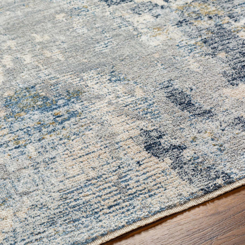 Close up of the Iryna Area Rug showing its charcoal, gray, and brown contemporary pattern and soft, textured polyester material. Texture