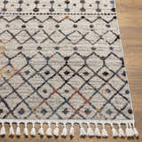 Close-up of Itogon Area Rug: geometric pattern in black, brick red, burnt orange, teal, and gray with white tassels. Front