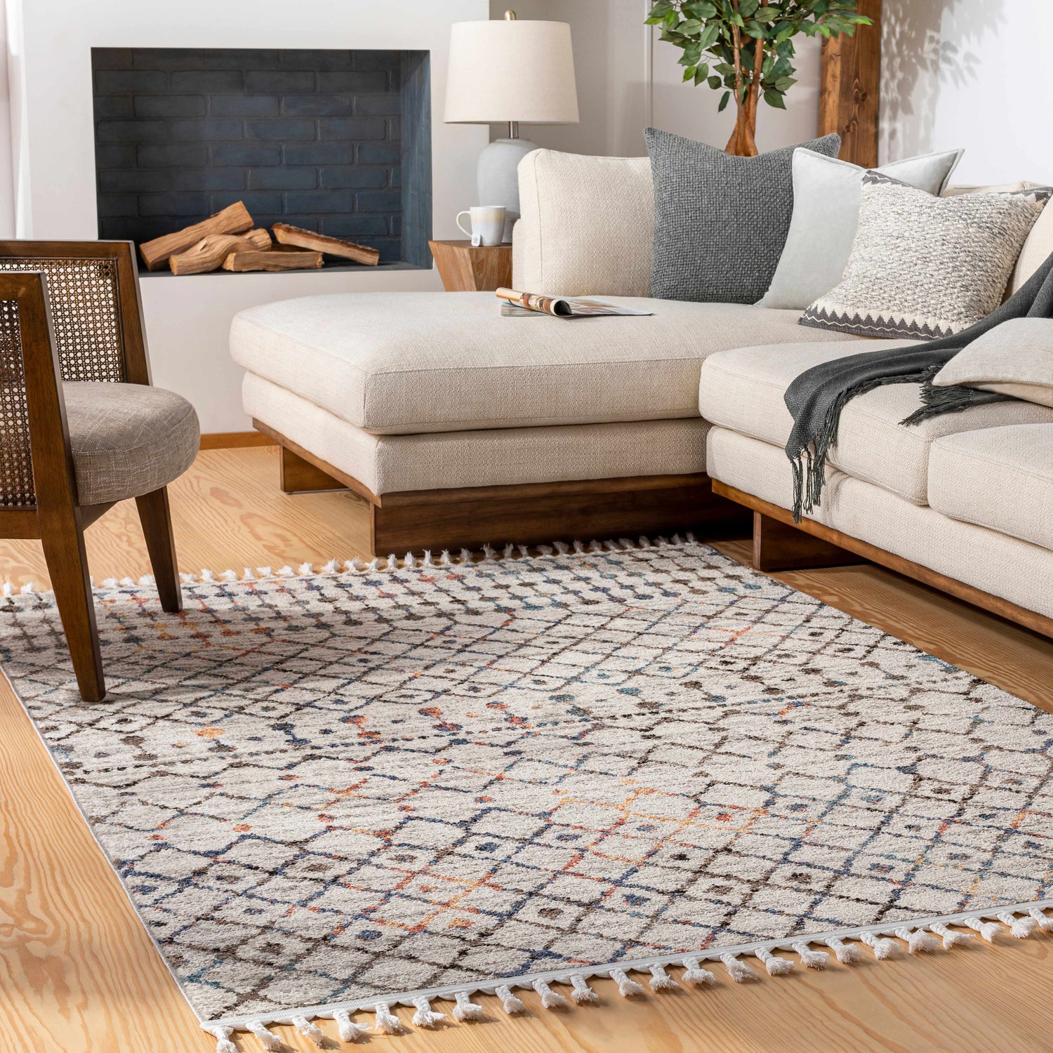 Living room scene with a geometric Itogon Area Rug. Beige sectional, wood floors, and fireplace create a cozy, transitional style. Roomscene-Rectangle