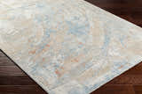 Close-up of Jaela Thick Luxe Area Rug showing its abstract design in gray, light brown, and hints of orange on dark brown wood floors. Corner