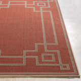 Close-up of a Brick Red Jarrell Area Rug with a light beige geometric border pattern. Front