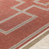 Close-up of the Jarrell Area Rug showing brick red olefin and light beige geometric pattern. Texture