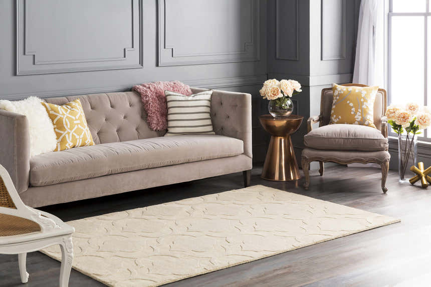 Living room scene with a tan Kake Carpet, gray walls, sofa, and accent chair. Contemporary style. Roomscene-Rectangle