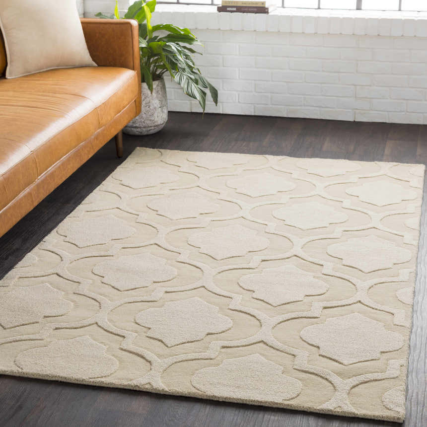 Living room scene with a tan leather sofa and the tan Kake Carpet featuring a contemporary quatrefoil design. Roomscene-Rectangle