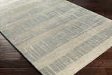 Close-up of Kalaheo Premium Rug, a sage and cream hand-knotted wool rug with a contemporary plaid design. Corner