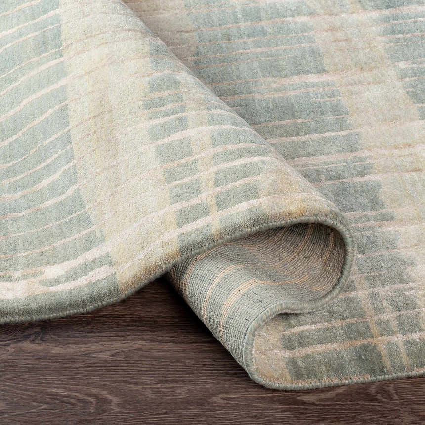 Close-up of the Kalaheo Premium Rug. Sage green wool rug with a contemporary design and hand-knotted construction. Fold