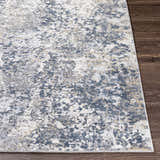 Close-up of the Kanahooka Area Rug showing its charcoal, blue, beige, and gray contemporary abstract design. Front