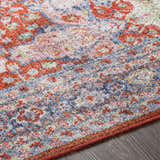 Close-up of the Kangundo Washable Area Rug showing the blush, cream, blue, and red traditional-style pattern. Texture