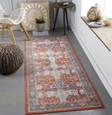 Entryway with a Kangundo Washable Area Rug in red and blue, styled with a white chair and woven pouf. Roomscene-Runner