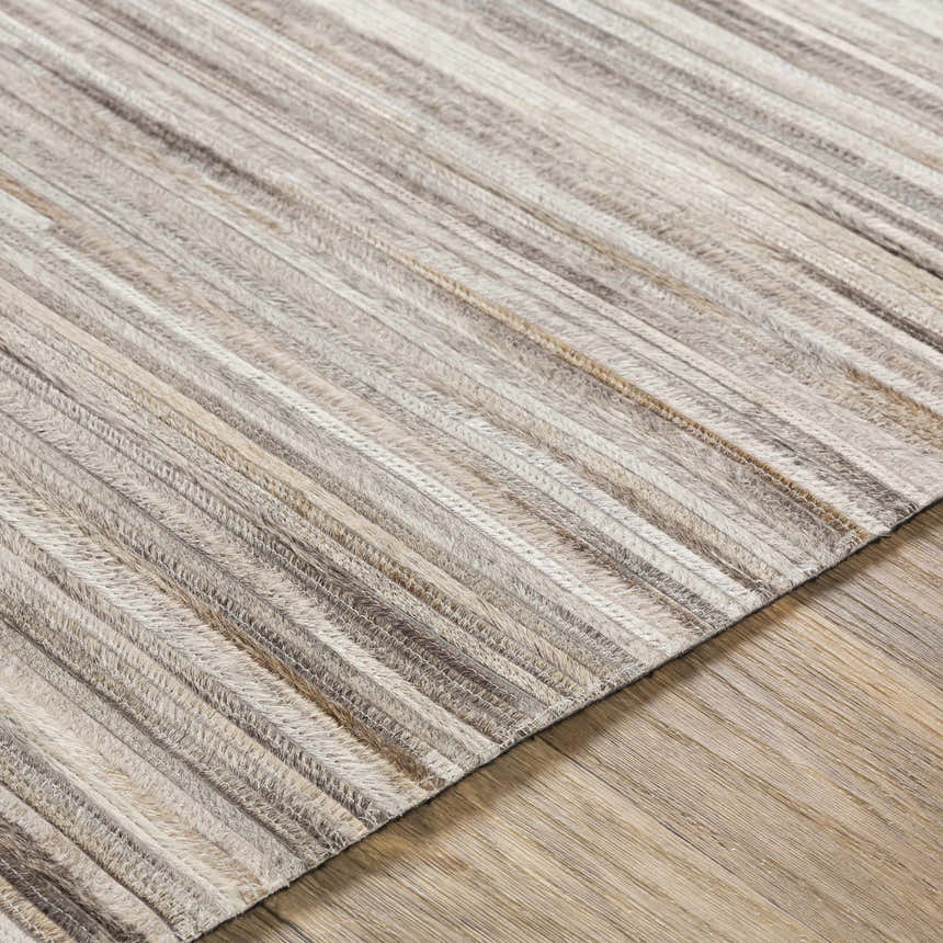 Close-up of the Karabar Premium Area Rug showing its hair on hide texture and beige, brown, and gray striped pattern. Texture