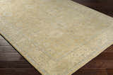 Close-up of the Karalee Handmade Wool Area Rug showcasing its beige, light olive, and dusty pink traditional pattern. Corner