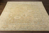Handmade Karalee Wool Area Rug in beige, brown, pink, olive, seafoam, slate, and yellow on a dark wood floor. Front