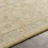 Close-up of the Karalee Handmade Wool Area Rug showing beige, dusty pink, and light olive colors. Hand-knotted texture detail. Texture