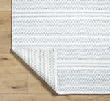 Close-up of the hand woven Kendi Cream Area Rug showing its texture, cream, light slate, and black colors. Fold