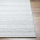 Close-up of the hand woven Kendi Cream Area Rug showing its cream and light slate textured pattern on wood floor. Front
