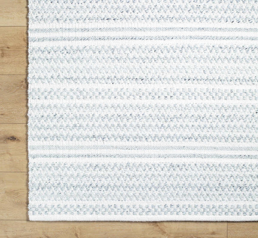 Close-up of the Kendi Cream Area Rug showing its hand-woven texture and light slate and cream striped pattern. Corner