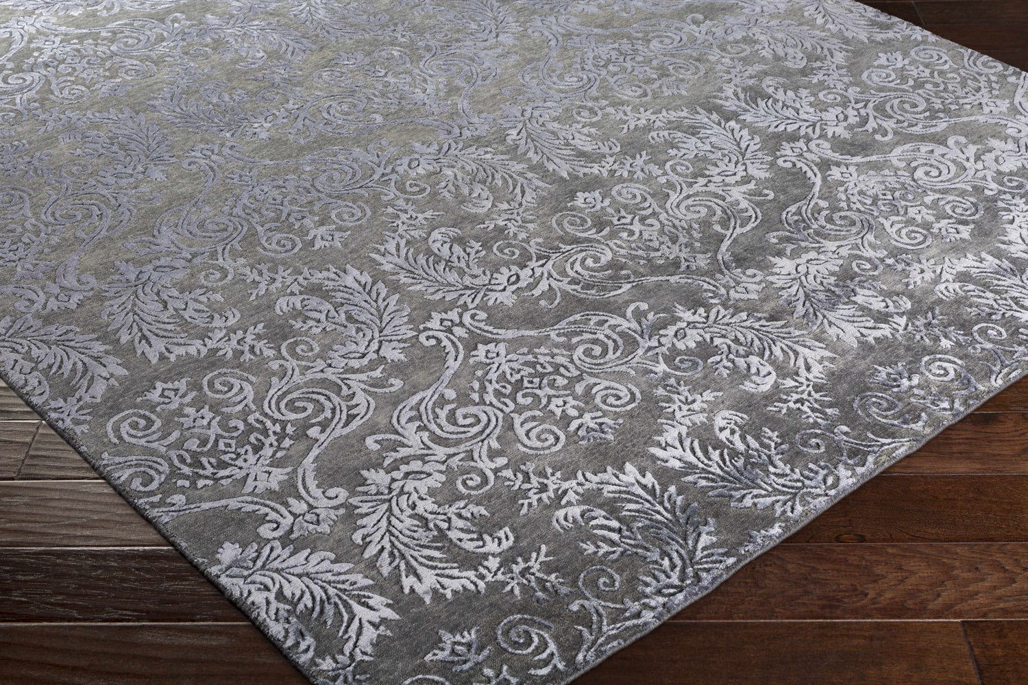 Close-up of the black Kechi Area Rug showing its traditional floral pattern and wool and viscose texture. Corner