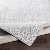Close-up of the Keenes Leopard Print Area Rug, charcoal and cream animal pattern, machine woven texture. Fold