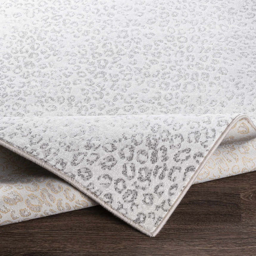 Close-up of the Keenes Leopard Print Area Rug, charcoal and cream animal pattern, machine woven texture. Fold