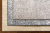 Close-up of Keenes Leopard Print Area Rug in charcoal, cream, and light gray colors and animal print pattern. Styleshot
