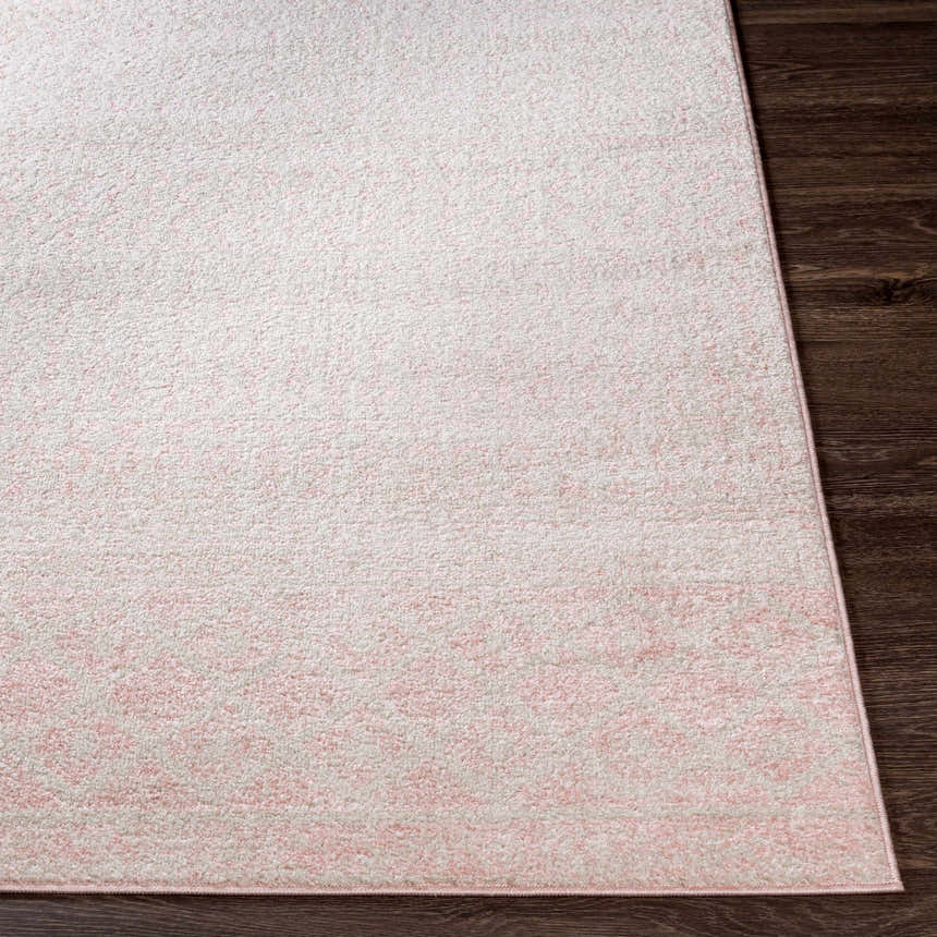 Close-up of the Constantin Blush Area Rug showing its blush and light gray colors and soft texture on dark wood floors. Front
