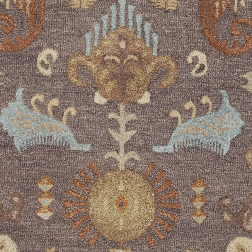 Detailed close-up of the hand-hooked Kelty Area Rug. Features beige, burnt orange, blue, and gray traditional floral patterns. Swatch
