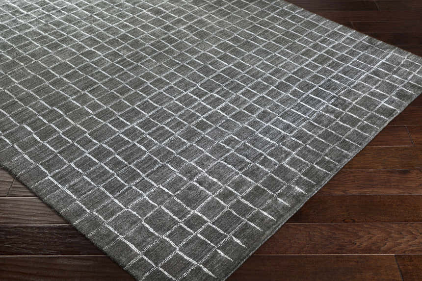 Close-up of the charcoal and white Kenesaw Clearance Rug showing its hand-knotted texture and contemporary grid pattern. Corner
