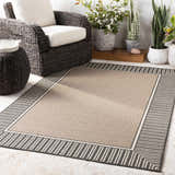 Patio scene with a beige Kidron Area Rug, black and white striped border, and wicker furniture. Roomscene-Rectangle