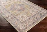 Close-up of the Klahanie Area Carpet showing its brick red, cream, and blue bohemian design on dark wood floors. Corner