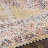 Close-up of Klahanie Area Carpet. Bohemian style rug in brick red, cream, blue, and mustard on a dark wood floor. Texture