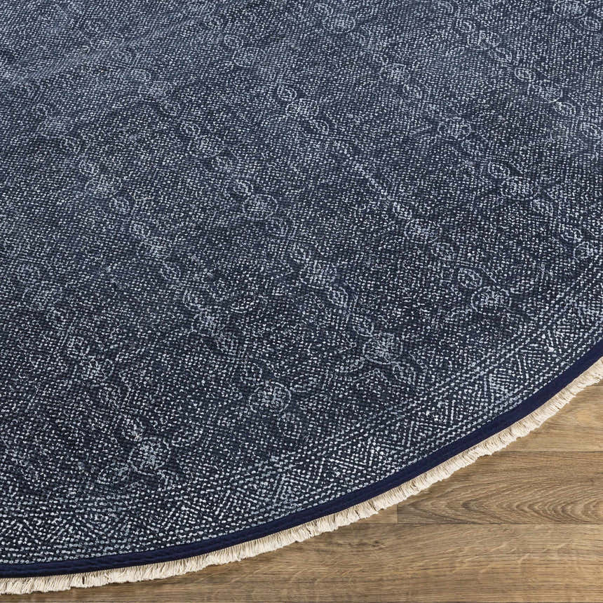 Close-up of the hand woven Kilburn Blue Cotton Round Carpet with a subtle pattern and fringe. Front