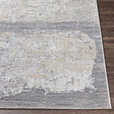 Close-up of the Kallangur Luxe Area Rug showing beige, gray, and charcoal abstract pattern and textured machine woven construction. Front