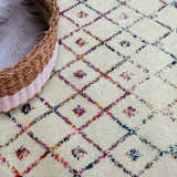 Close-up of the Marash KMRSH-4600 area rug featuring a colorful diamond pattern on an off-white background. Styleshot