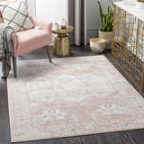 Living room scene with a pink armchair and the Kendal Area Rug in cream, light beige, and pale pink. Roomscene-Rectangle