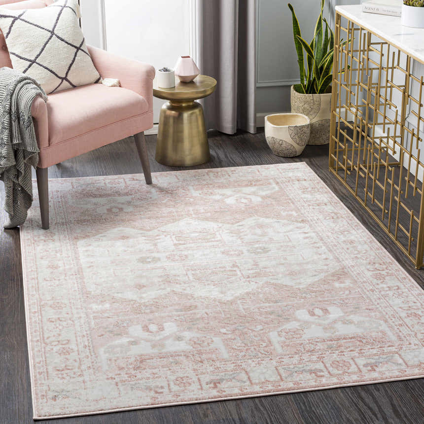 Living room scene with a pink armchair and the Kendal Area Rug in cream, light beige, and pale pink. Roomscene-Rectangle