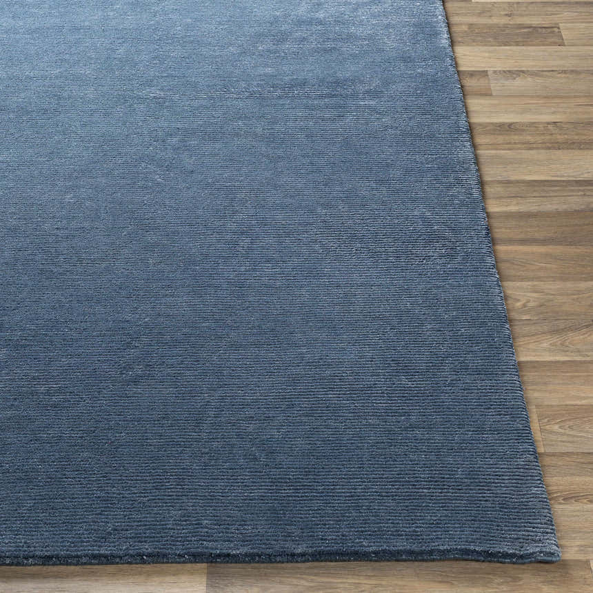 Close up of the blue Kendall Carpet showing its hand knotted texture and wool viscose blend on a wood floor. Front