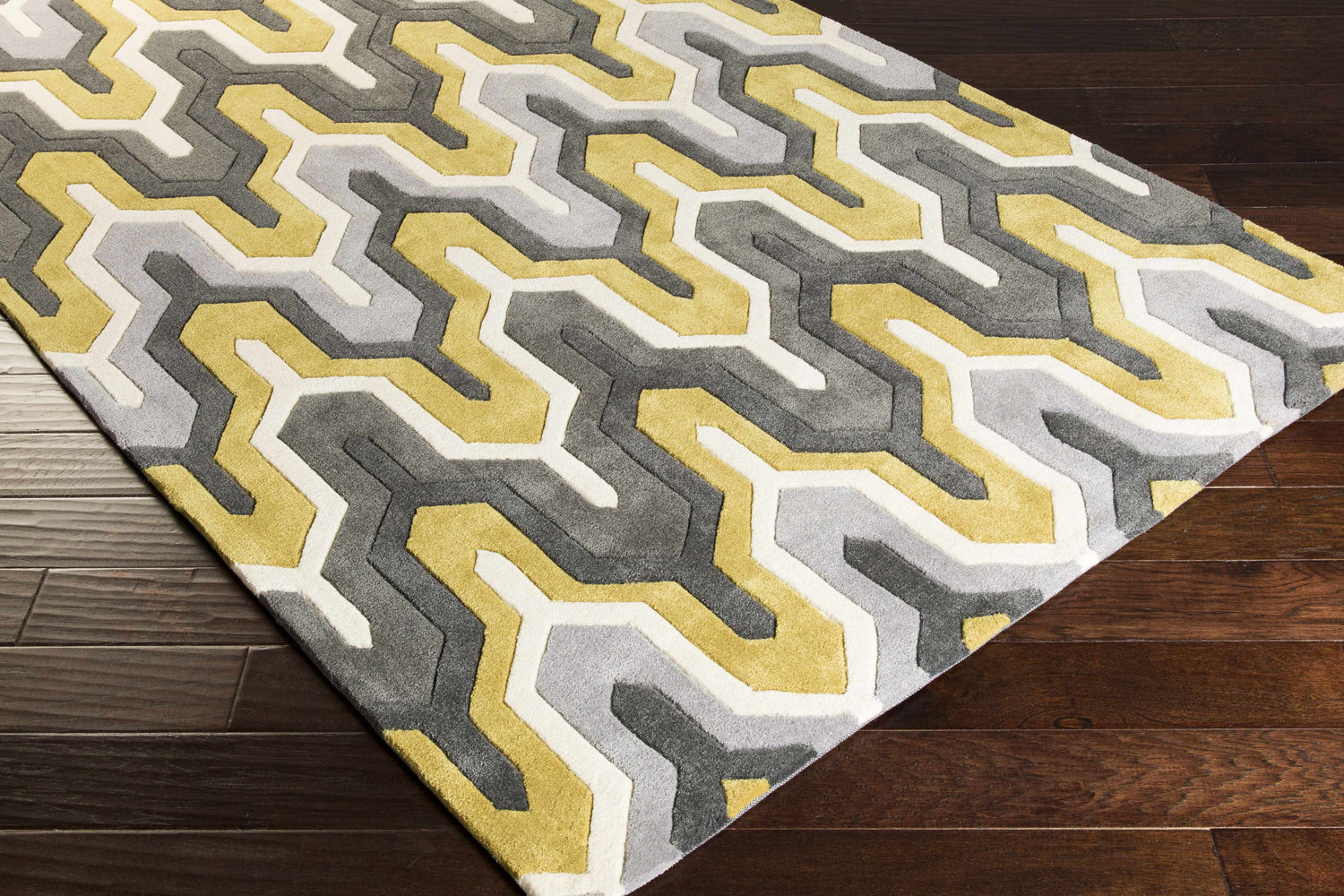 Close-up of the Knighton Area Rug: charcoal, mustard, slate blue, and white geometric pattern on a hand-tufted rug. Corner