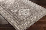 Close-up of the Kingscourt Washable Area Rug in cream, gray, and brown on dark wood floors. Traditional oriental pattern. Corner