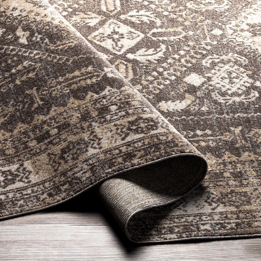Close-up of the Kingscourt Washable Area Rug showing its cream, beige, and brown traditional oriental pattern. Fold