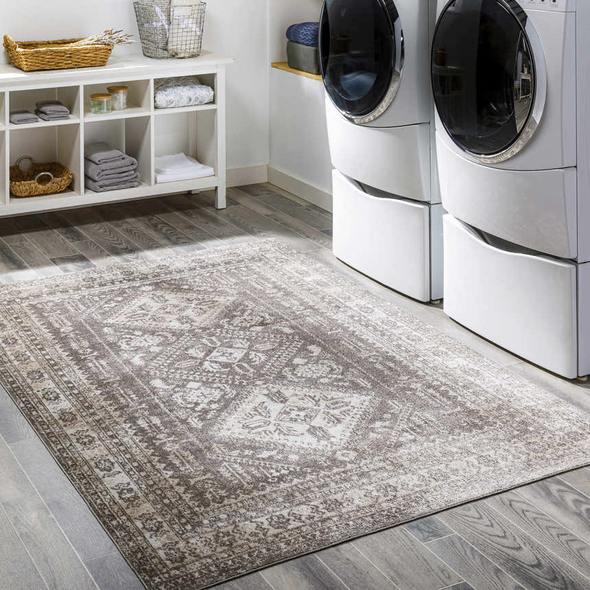 Laundry room with white washer/dryer and Kingscourt Washable Area Rug in cream, brown, and gray. Roomscene-Rectangle