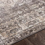 Close-up of the Kingscourt Washable Area Rug. Cream, dark brown, and beige tones in a traditional, distressed pattern. Texture