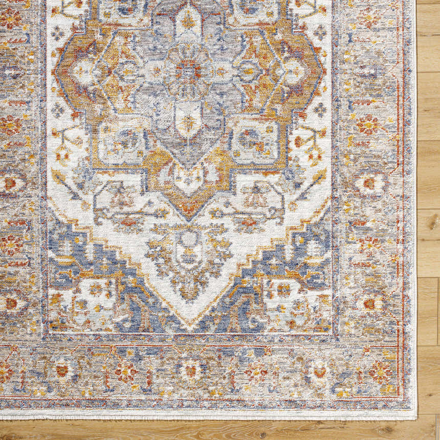 Close-up of Kokstad Area Rug. Traditional floral pattern in arctic stone, beige, brown, mocha, and taupe on wood floor. Corner