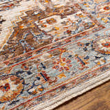 Close-up of the Kokstad Area Rug showing its traditional floral pattern and colors: arctic stone, beige, brown, and taupe. Texture