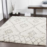 Living room scene with a Kunia Area Rug. The rug is ivory with a charcoal geometric pattern. Bench and decor complete the look. Roomscene-Rectangle