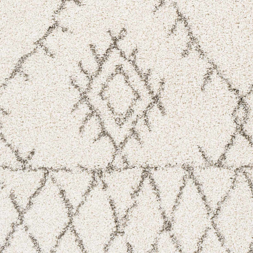 Close up of the Kunia Area Rug showing the ivory shag texture and charcoal geometric pattern. Swatch