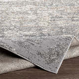 Close-up of the Kyabram textured abstract area rug showing beige, charcoal, gray, and off-white tones. Fold